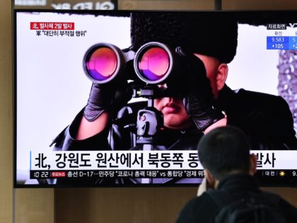 A man watches a news broadcast showing file footage of North Korean leader Kim Jong Un, at