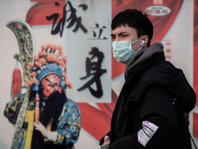 A man wearing a protective mask to help stop the spread of a deadly virus which began in Wuhan, looks on at the Beijing railway station in Beijing on January 27, 2020. - China on January 27 extended its biggest national holiday to buy time in the fight against a …