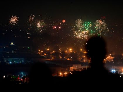 People watch fireworks burst over Los Angeles, California on July 4, 2020 during celebrations for the Fourth of July holiday, amid the coronavirus pandemic. (Photo by Frederic J. BROWN / AFP) (Photo by FREDERIC J. BROWN/AFP via Getty Images)
