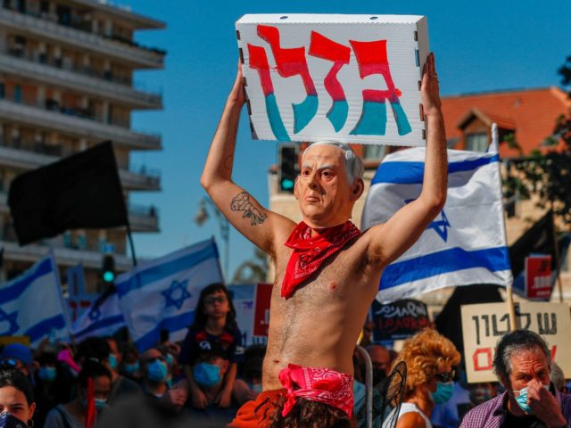 An Israeli protester, wearing swim suits and a mask with the effigy of Pime Misiter Benjamin Netanyahu, takes part in a demonstration against him outside his official residence in Jerusalem on July 24, 2020. - Public confidence in the government has been dented by a recent wave of contradictory emergency …