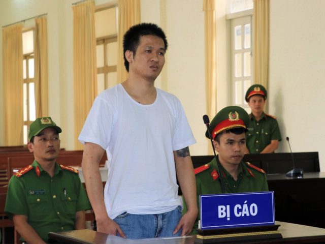 This picture taken and released by the Vietnam News Agency on July 7, 2020 shows Vietnamese national Nguyen Quoc Duc Vuong (C) during his court trial in Vietnam's Lam Dong province. - A Vietnamese man was sentenced on July 7 to eight years in prison for live streaming videos "humilitating" …