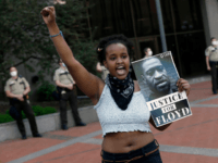 In this May 28, 2020 file photo, a protester holds a photo of George Floyd during a protest in Minneapolis over Floyd's death. Video from the body cameras of two officers charged in the death of Floyd is being made available for public viewing by appointment on Wednesday, July 15 …