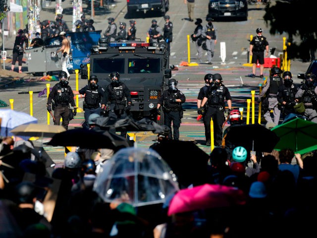 Protesters confront police at the former location of the Capitol Hill Organized Protest (CHOP) after a "Youth Day of Action and Solidarity with Portland" demonstration in Seattle, Washington on July 25, 2020. - Police in Seattle used flashbang grenades and pepper spray Saturday against protesters who set fire to construction …