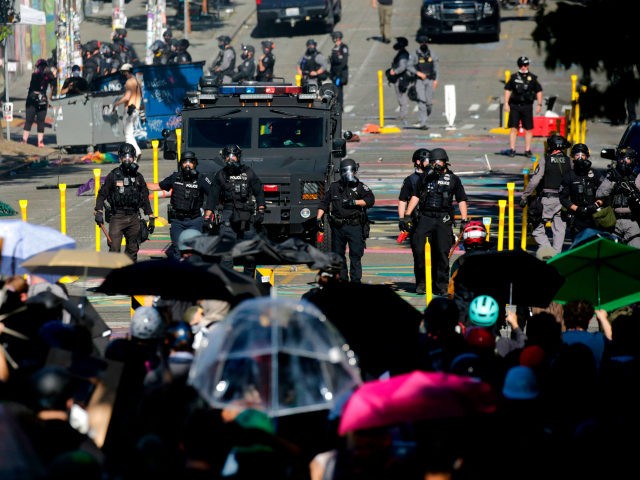 Protesters confront police at the former location of the Capitol Hill Organized Protest (C