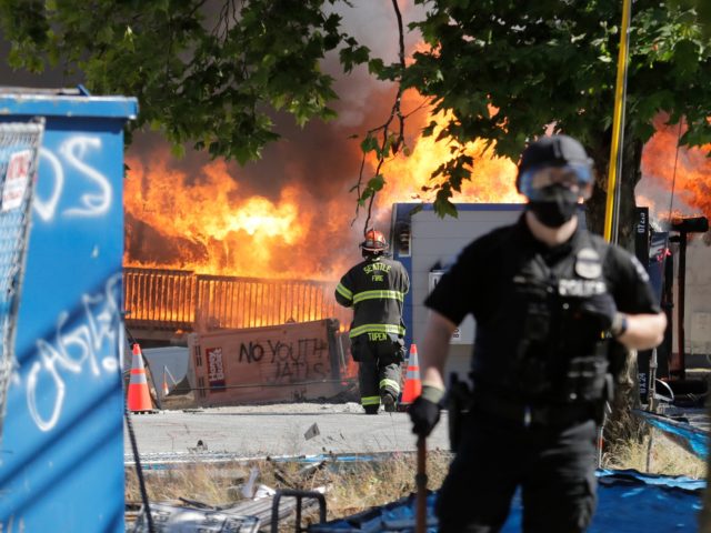 Construction buildings burn near the King County Juvenile Detention Center, Saturday, July 25, 2020, in Seattle, shortly after a group of protesters left the area. A large group of protesters were marching Saturday in Seattle in support of Black Lives Matter and against police brutality and racial injustice. Protesters broke …