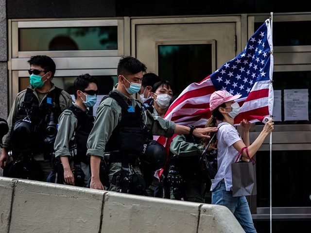 Police remove a woman holding a US flag from outside the US consulate during a march to celebrate US Independence Day in Hong Kong on July 4, 2020. (Photo by ISAAC LAWRENCE / AFP) (Photo by ISAAC LAWRENCE/AFP via Getty Images)