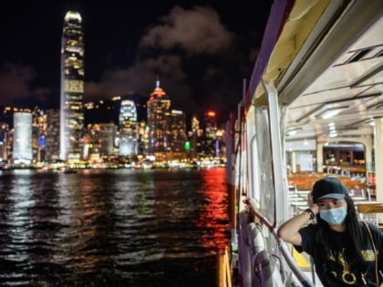 TOPSHOT - A woman wearing a face mask takes a Star Ferry in Victoria Harbour from Kowloon side to Hong Kong Island (back) on July 27, 2020. - Everyone in Hong Kong will have to wear masks in public from this week, authorities said on July 27, as they unveiled …
