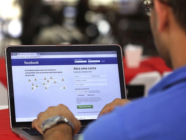 FILE - In this Thursday, Jan. 4, 2018, file photo, a man enters his Facebook page, at a re