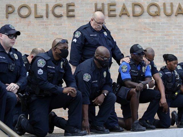 Members of the Austin Police Department kneel in front of demonstrators who gathered in Austin, Texas, Saturday, June 6, 2020, to protest the death of George Floyd, a black man who was in police custody in Minneapolis. Floyd died after being restrained by Minneapolis police officers on Memorial Day. (AP …