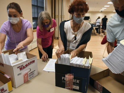 Volunteers sort mail-in ballots on Primary Day, Tuesday, Aug. 11, 2020, in Glastonbury, Co