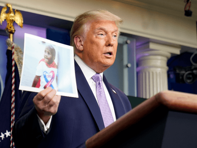 President Donald Trump holds a photo of LeGend Taliferro as he speaks at a news conference in the James Brady Press Briefing Room at the White House, Thursday, Aug. 13, 2020, in Washington. LeGend Taliferro, 4, was shot and died while he slept in his apartment in Kansas City, Mo., …