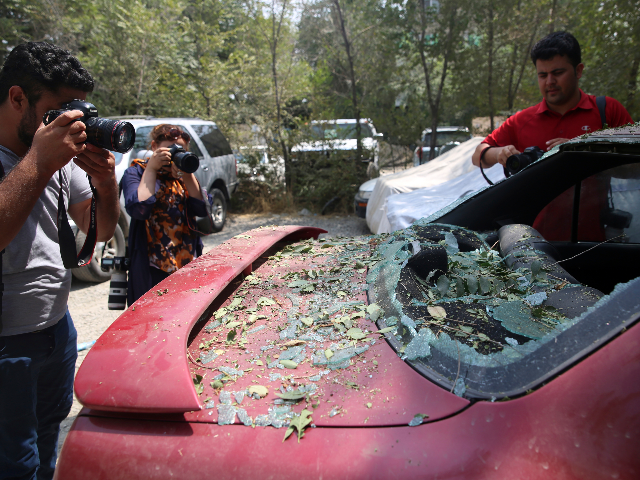 Photographers take a pictures of a damaged car after a rocket attack in Kabul, Afghanistan, Tuesday, Aug. 18, 2020, Several mortar shells slammed into various part of Kabul on Tuesday morning as Afghans marked their country's Independence Day amid new uncertainties over the start of talks between the Taliban and …