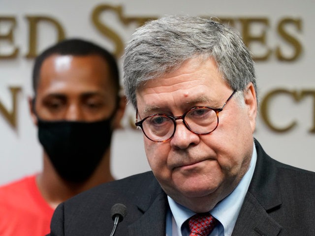 Attorney General William Barr talks to the media during a news conference about Operation Legend, a federal task force formed to fight violent crime in several cities, Wednesday, Aug. 19, 2020, in Kansas City, Mo. Behind Barr is Raphael Taliferro, father of 4-year-old LeGend Taliferro who was shot and killed …
