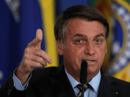Brazilian President Jair Bolsonaro points to the press as he refers to his recovery from C