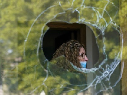 A woman is seen through a broken window at the Harborside Academy Monday, Aug. 24, 2020, i