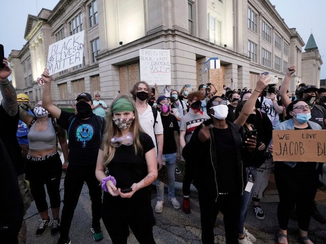 People gather Tuesday, Aug. 25, 2020 to protest in Kenosha, Wis. Anger over the Sunday sho