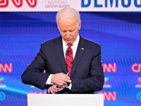 Former Vice President Joe Biden, check his watch during a commercial break as he participates in a Democratic presidential primary debate at CNN Studios, Sunday, March 15, 2020, in Washington. (AP Photo/Evan Vucci)