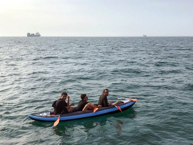 Three migrants who were attempting to cross The English Channel from France to Britain are seen as they drift in an inflatable canoe off the French coast at Calais on August 4, 2018, before being rescued by lifeguards of Les Sauveteurs en Mer (SNSM). (Photo by STR / AFP) (Photo …