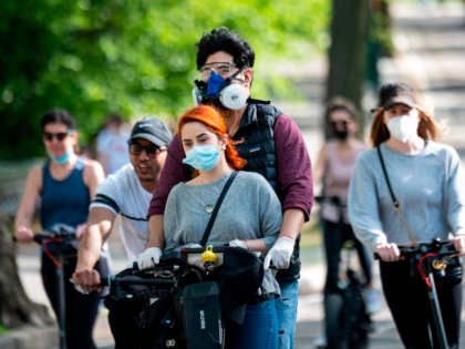 People wearing masks ride a scooter in Central Park on May 16, 2020 in New York City, amid the coronavirus pandemic. (Photo by Johannes EISELE / AFP) (Photo by JOHANNES EISELE/AFP via Getty Images)