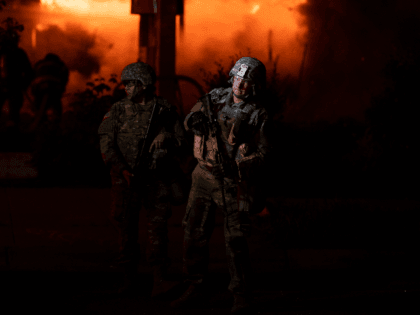 Members of the National Guard hold a perimeter as a fire crew works to put out a fire at a gas station on Lake Street on May 29, 2020 in Minneapolis, Minnesota. Protests have been ongoing in the state and around the country since George Floyd's death while in police …