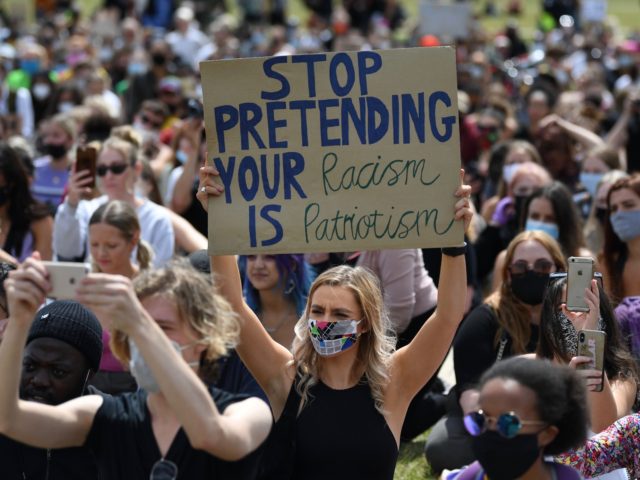 TOPSHOT - Activists, some wearing face coverings or face masks as a precautionary measure against COVID-19, hold placards as they attend a Black Lives Matter protest in Hyde Park, central London on June 20, 2020. - British activists continue protests sparked by the death in police custody of George Floyd, …