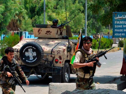 Afghan soldiers take up position outside a prison during an ongoing raid in Jalalabad on A