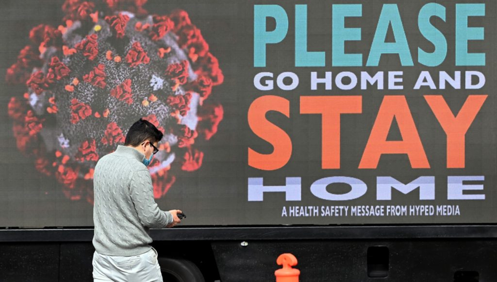 A man walks past a sign on a truck in Melbourne as the city enforces strict lockdown restrictions after a fresh outbreak of the COVID-19 coronavirus. - Australia's worst-hit state of Victoria reported 725 new cases and 15 coronavirus deaths on August 5, including a man in his 30s, making it the country's deadliest day of the pandemic to date. (WILLIAM WEST/AFP via Getty Images) 