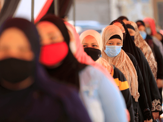 Egyptians wearing face masks against Covid-19 queue up to vote on August 11, 2020 for a ne