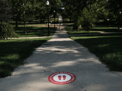 A lone person makes their way through the 'Oval' at Ohio State University, a part of campus which, during the school year, is popular with students and faculty of the university, on August 13, 2020 in Columbus, Ohio. Incoming students living in the campus dormitories began moving in on the …