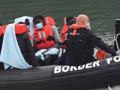 UK Border Force officials transfer migrants in a Patrol Vessel after they were intercepted