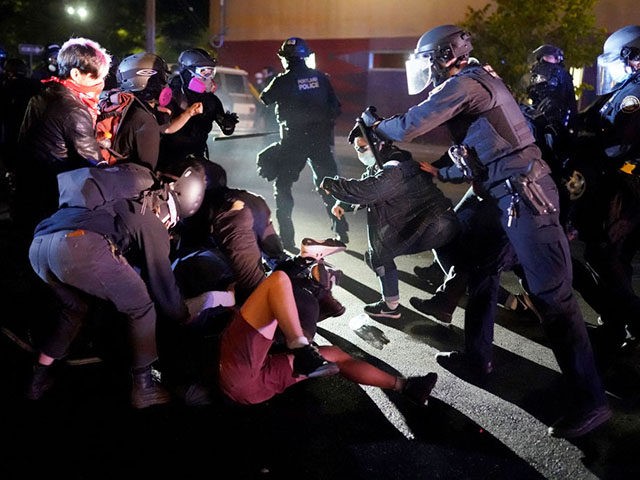 PORTLAND, OR - AUGUST 22: Protesters and Portland police clash while dispersing a crowd ga