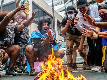 Protesters set fire to an US National flag outside the Hennepin County Government Plaza 