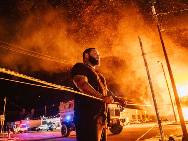 KENOSHA, WI - AUGUST 24: A man looks over warning tape during a second night of rioting on August 24, 2020 in Kenosha, Wisconsin.  The civil unrest occurred after the shooting of Jacob Blake, 29, on Aug. 23.  Blake was shot multiple times in the back by Wisconsin police officers after trying to get into the driver's side of a vehicle.  (Photo by Brandon Bell/Getty Images)