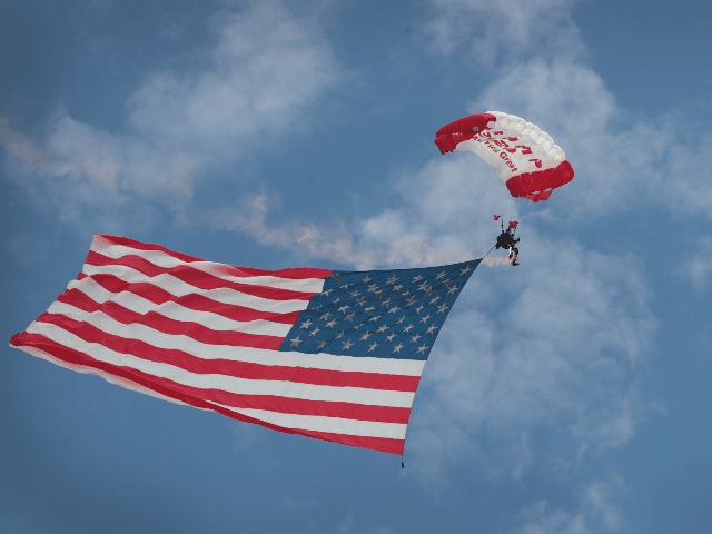 Former Army Golden Knights parachutist Dana Bowman brings in the Flag before the start of
