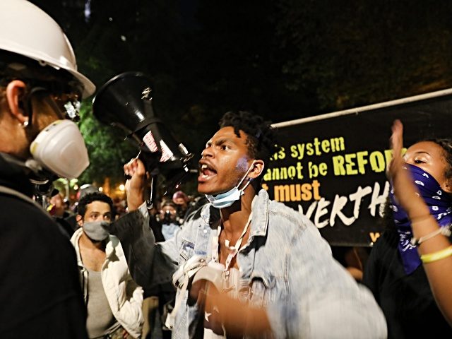 PORTLAND, OREGON - JULY 28: Protesters have a fight as they gather in protest in front of