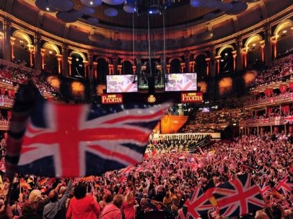 People wave flags at the Royal Albert Hall in west London on September 7, 2013 during the last night of the Proms. US conductor Marin Alsop became the first woman to conduct the Last Night of the Proms in its 118-year history. AFP PHOTO/CARL COURT (Photo credit should read CARL …