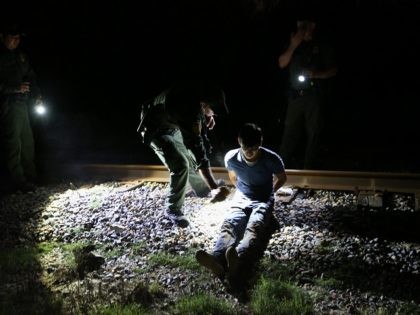 MCALLEN, TX - SEPTEMBER 08: U.S. Border Patrol agents spray an undocumented immigrant with mosquito repellant along the railroad tracks near the Rio Grande River at the U.S.-Mexico border on September 8, 2014 near McAllen, Texas. Thousands of undocumented immigrants continue to cross illegally into the United States, although the …