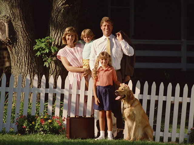 Family by white picket fence