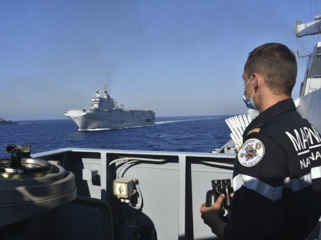 This photo provided Friday Aug.14, 2020 by the French Defense Ministry shows the French Tonnerre helicopter carrier, center, escorted by Greek and French military vessels during a maritime exercise in the Eastern Mediterranean, Thursday, Aug. 13, 2020. Greece's prime minister warmly thanked France Thursday for boosting its military presence in …