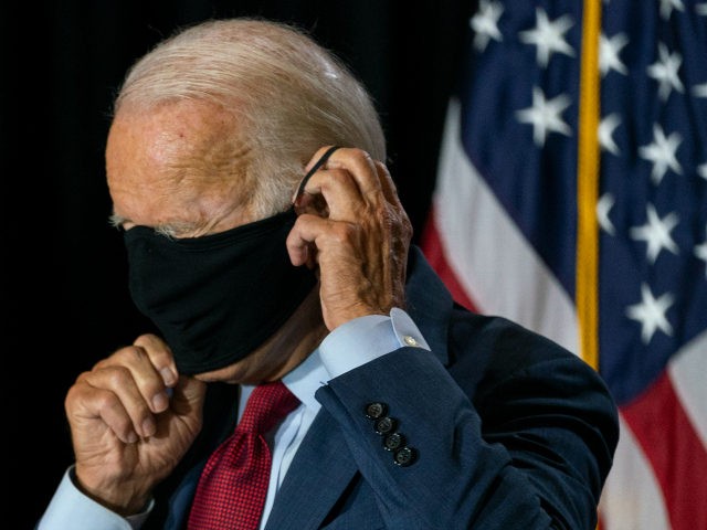 Democratic presidential candidate former Vice President Joe Biden joined by his running mate Sen. Kamala Harris, D-Calif., replaces his face mask after speaking at the Hotel DuPont in Wilmington, Del., Thursday, Aug. 13, 2020. (AP Photo/Carolyn Kaster)
