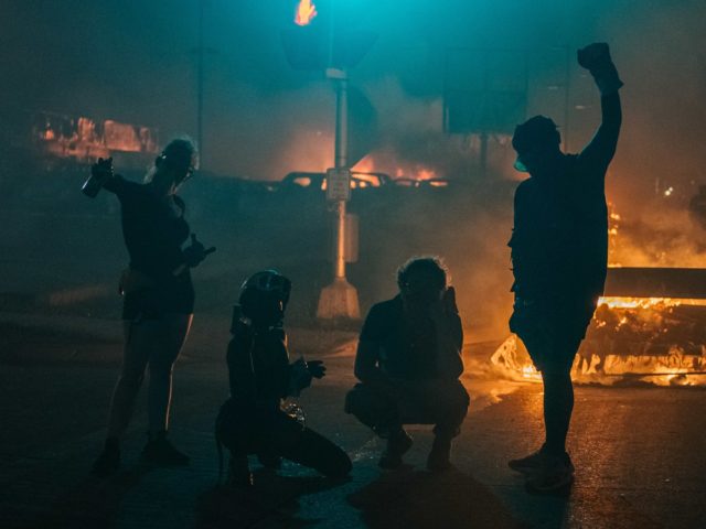 KENOSHA, WI - AUGUST 24: Demonstrators pose for a photograph on August 24, 2020 in Kenosha, Wisconsin. This is the second night of rioting after the shooting of Jacob Blake, 29, on August 23. Blake was shot multiple times in the back by Wisconsin police officers after attempting to enter …