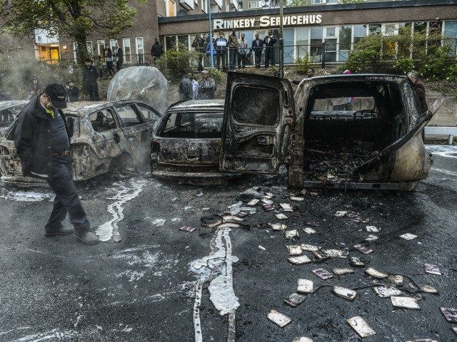 A bystander checks the debris of a burnt out cars in the Stockholm suburb of Rinkeby after youths rioted in several different suburbs around Stockholm, Sweden for a fourth consecutive night on May 23, 2013. In the suburb of Husby, where the riots began on Sunday in response to the …
