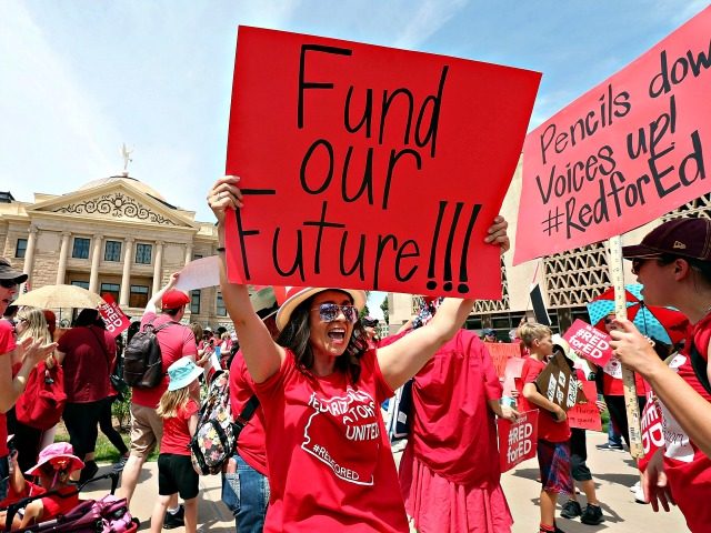 PHOENIX, AZ - APRIL 26: An Arizona teacher holds up a sign in front of the State Capitol during a #REDforED rally on April 26, 2018 in Phoenix, Arizona. Teachers state-wide staged a walkout strike on Thursday in support of better wages and state funding for public schools. (Photo by …