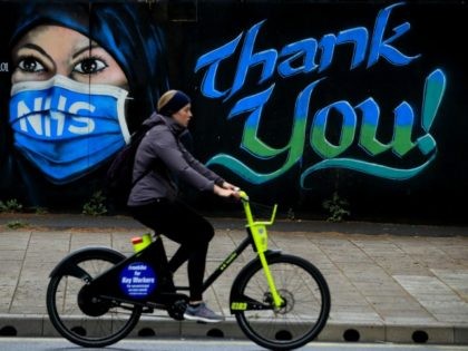 LONDON, ENGLAND - APRIL 29: A woman cycles past a piece of street art, created by The Artful Dodger, thanking the NHS on April 29, 2020 in London, England. British Prime Minister Boris Johnson, who returned to Downing Street this week after recovering from Covid-19, said the country needed to …