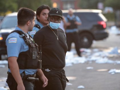 CHICAGO, ILLINOIS - AUGUST 10: Police officers detain a man who was found inside of a Best