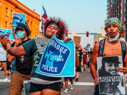 Protesters march near the Minneapolis 1st Police precinct during a demonstration against police brutality and racism on August 24, 2020 in Minneapolis, Minnesota. - It was the second day of demonstrations in Kenosha after video circulated Sunday showing the shooting of Jacob Blake -- multiple times, in the back, as he …