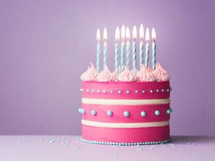 Pink birthday cake with nine candles