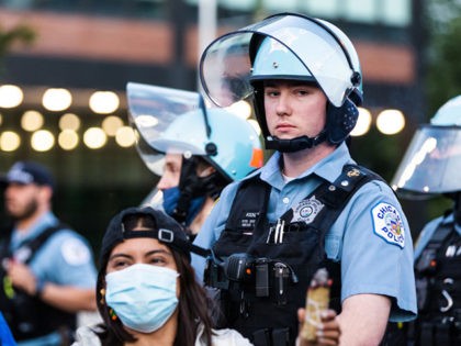 CHICAGO, ILLINOIS - JUNE 06: A protester burns sage as a police officer looks ahead on June 06, 2020 in Chicago, Illinois. This is the 12th day of protests since George Floyd died in Minneapolis police custody on May 25. (Photo by Natasha Moustache/Getty Images)