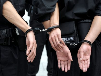 Chinese police handcuff their coleagues during a crowd control drill in Beijing on October