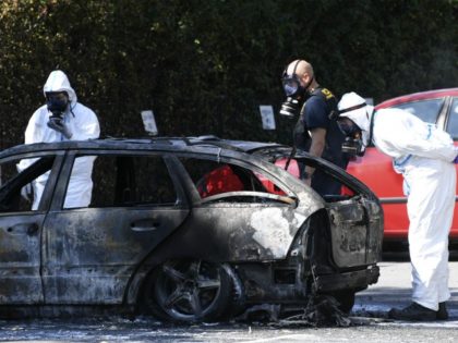 Police forensic officers inspect a burnedßout car near the scene where a woman was shot dead in the Ribersborg district of Malmo, Sweden on August 26, 2019. (Photo by Johan NILSSON / TT News Agency / AFP) / Sweden OUT (Photo credit should read JOHAN NILSSON/AFP via Getty Images)